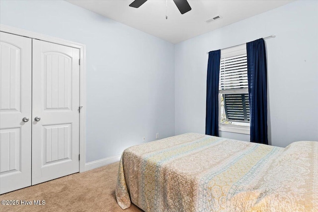 bedroom featuring visible vents, a closet, carpet flooring, baseboards, and ceiling fan