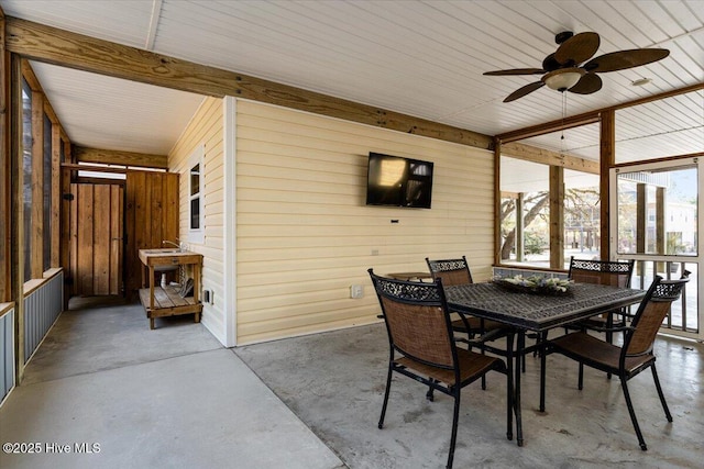 134 NE 11th St, Oak Island, NC 28465 - dining space with concrete flooring, a ceiling fan, and wood walls