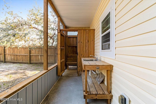 view of patio with a sink and fence