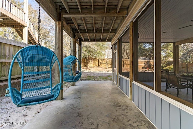 view of patio featuring fence and a sunroom