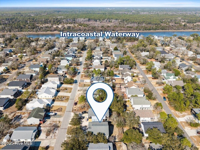 drone / aerial view with a forest view, a water view, and a residential view