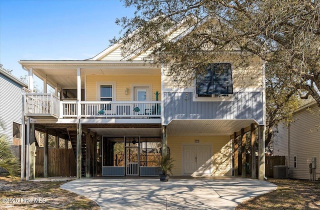 view of front of house featuring central AC, a porch, stairway, concrete driveway, and a carport