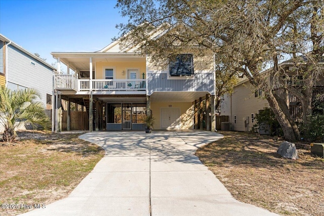 coastal home with central air condition unit, a carport, and driveway