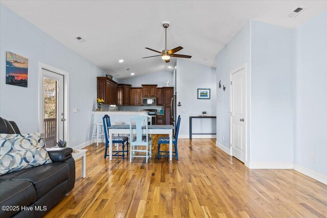 134 NE 11th St, Oak Island, NC 28465 - living room featuring vaulted ceiling, ceiling fan, light wood-style floors, and baseboards