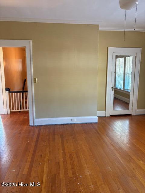 empty room featuring ornamental molding and wood-type flooring