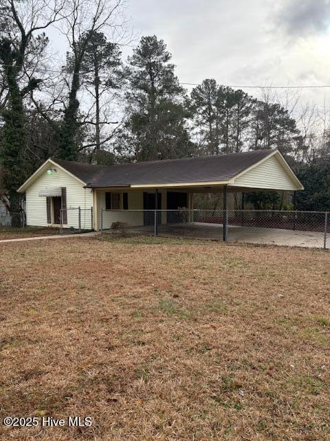 ranch-style home featuring a carport and a front yard