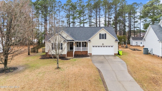 view of front of home featuring cooling unit, a garage, a front yard, and covered porch