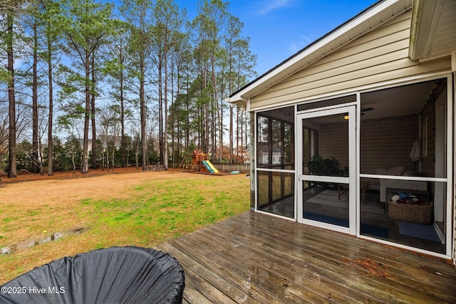 wooden terrace with a yard, a sunroom, and a playground