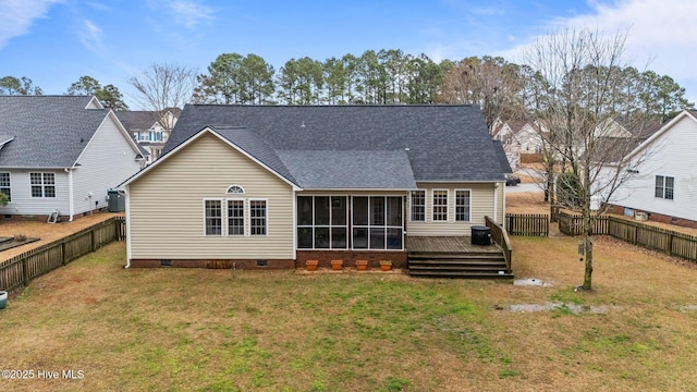 back of house featuring a wooden deck, a sunroom, and a lawn