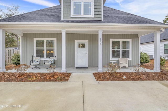 view of front of home with a shingled roof, covered porch, and board and batten siding