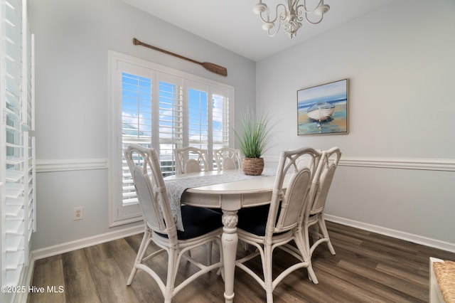 dining area with dark hardwood / wood-style flooring and an inviting chandelier