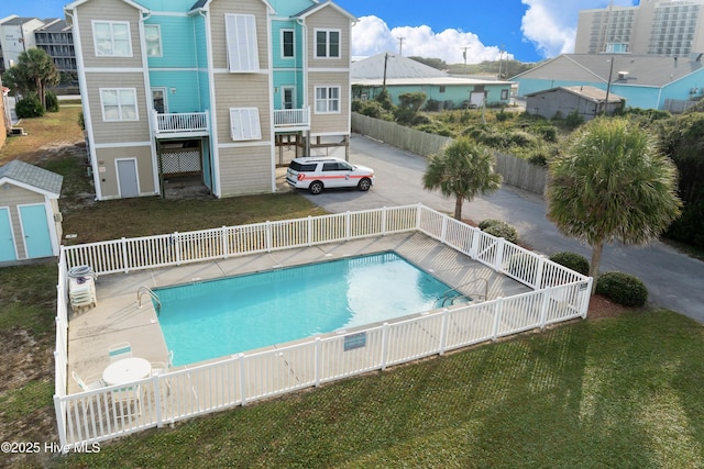 view of swimming pool featuring a shed and a yard