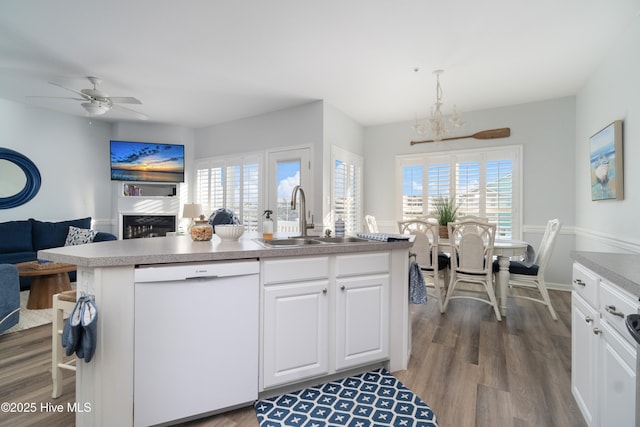 kitchen featuring hardwood / wood-style floors, dishwasher, sink, white cabinets, and hanging light fixtures