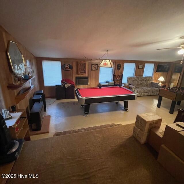 game room featuring pool table, wooden walls, and ceiling fan