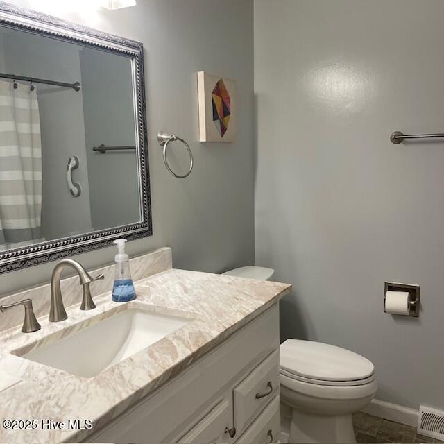 bathroom with walk in shower, tile patterned floors, vanity, and toilet