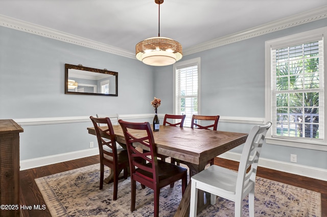 dining area with dark hardwood / wood-style flooring and crown molding