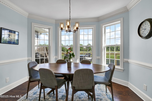 dining area with ornamental molding, dark wood-type flooring, and a notable chandelier