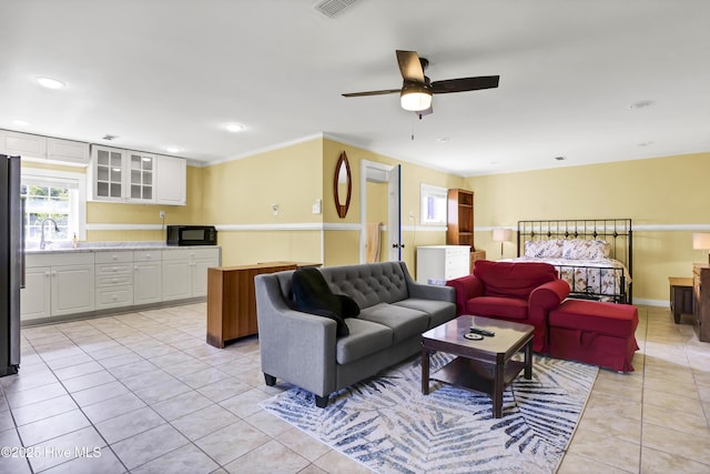 living room with sink, light tile patterned floors, and ceiling fan