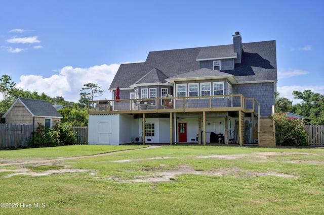 rear view of property with a wooden deck and a yard