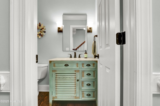 bathroom featuring hardwood / wood-style flooring, vanity, toilet, and crown molding