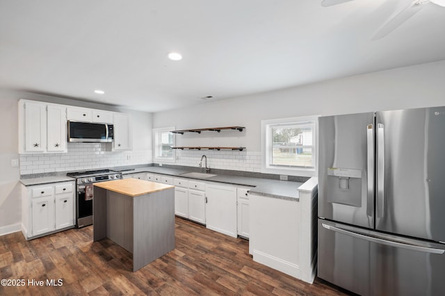 kitchen featuring a kitchen island, white cabinetry, appliances with stainless steel finishes, and sink