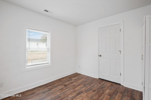 unfurnished room with dark wood-type flooring