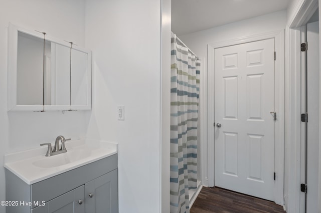 bathroom featuring wood-type flooring, vanity, and walk in shower