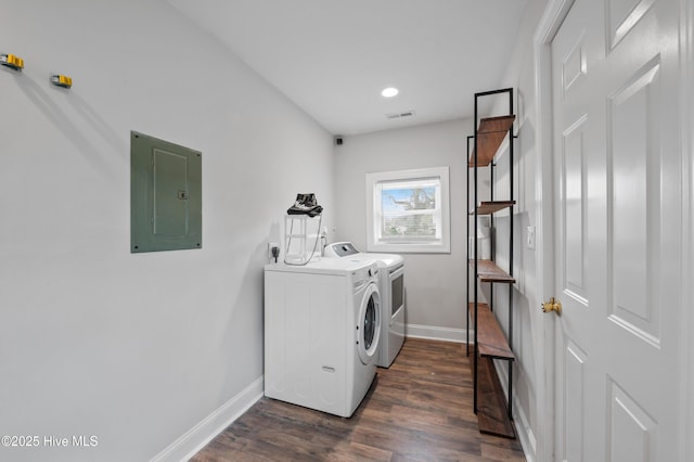 laundry area featuring dark hardwood / wood-style floors, electric panel, and washer and clothes dryer