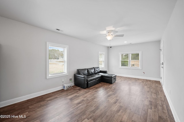 living area featuring ceiling fan and dark hardwood / wood-style floors