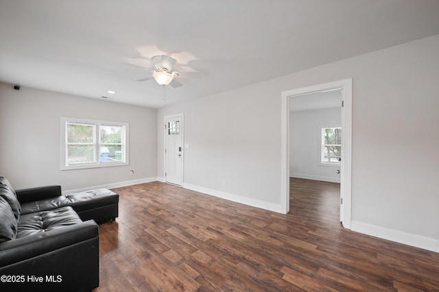 living room featuring dark wood-type flooring and ceiling fan