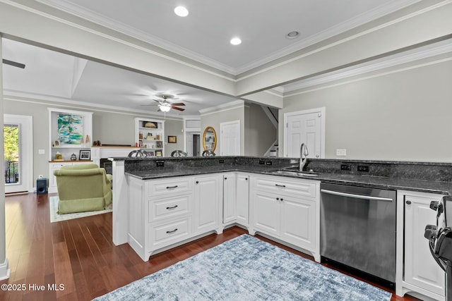 kitchen with open floor plan, a peninsula, stainless steel dishwasher, and white cabinets