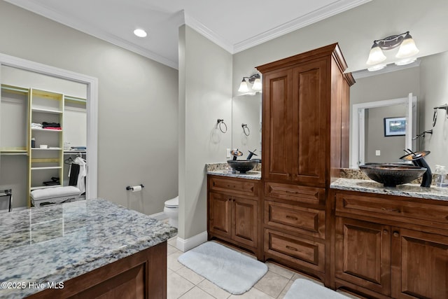 full bath with a spacious closet, ornamental molding, tile patterned flooring, and vanity