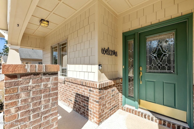 entrance to property featuring brick siding