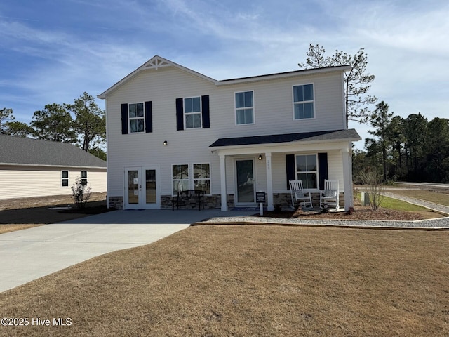 view of front facade featuring a front yard, a porch, french doors, and stone siding