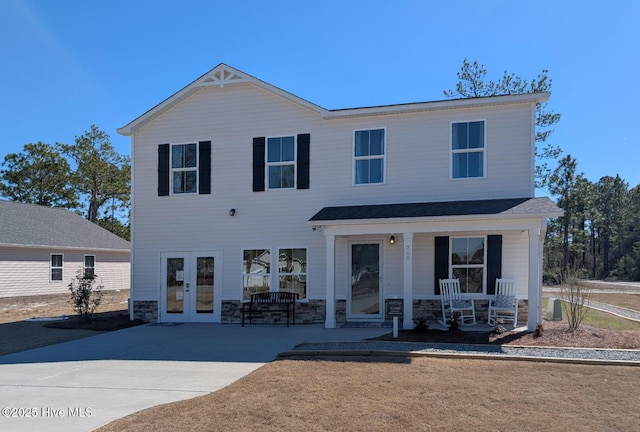 view of front of home featuring stone siding, french doors, and a porch