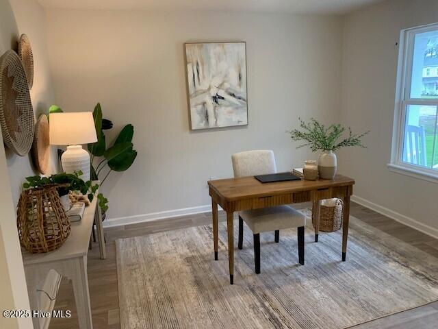 home office with baseboards and wood finished floors