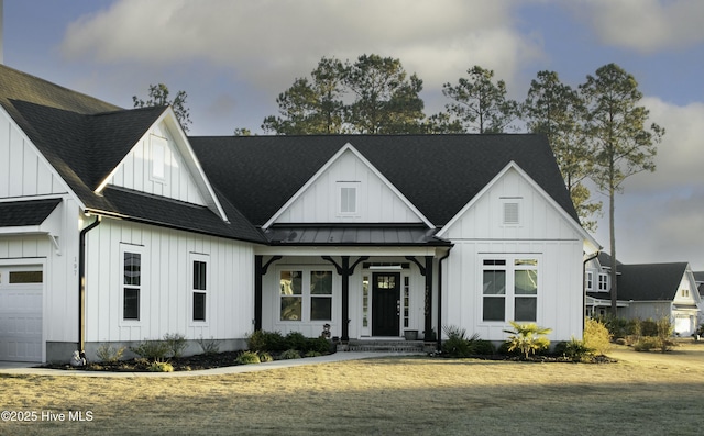 modern farmhouse featuring metal roof, an attached garage, roof with shingles, board and batten siding, and a standing seam roof