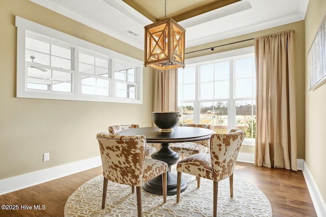 dining room with hardwood / wood-style flooring, ornamental molding, and a chandelier