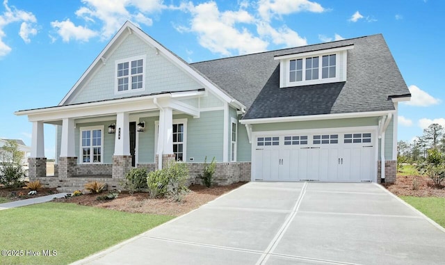 craftsman house with a garage, covered porch, and a front yard