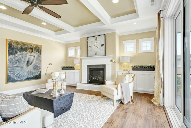 living area featuring beam ceiling, crown molding, and light wood-type flooring