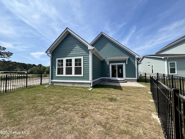 rear view of house featuring a fenced backyard and a yard