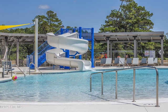 pool featuring fence, a water slide, a patio area, and playground community
