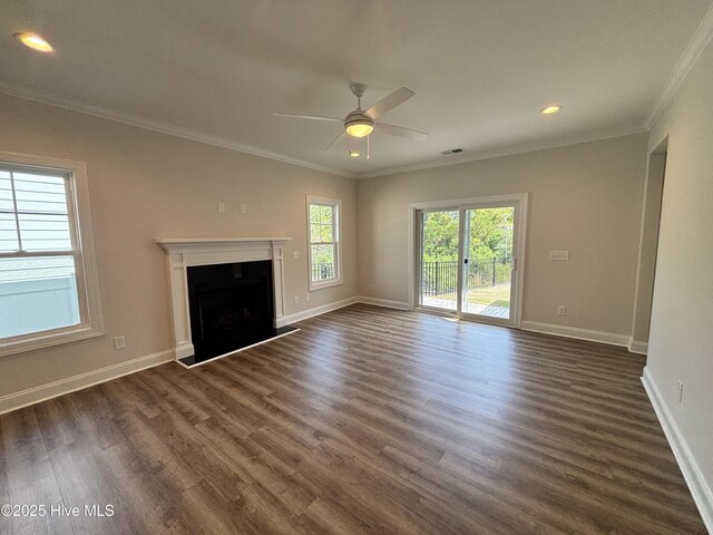 unfurnished living room featuring baseboards, ornamental molding, a ceiling fan, and dark wood-type flooring