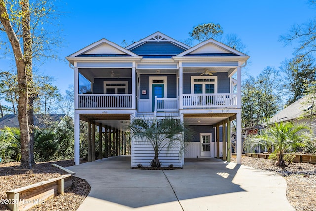 beach home with covered porch, ceiling fan, concrete driveway, and a carport