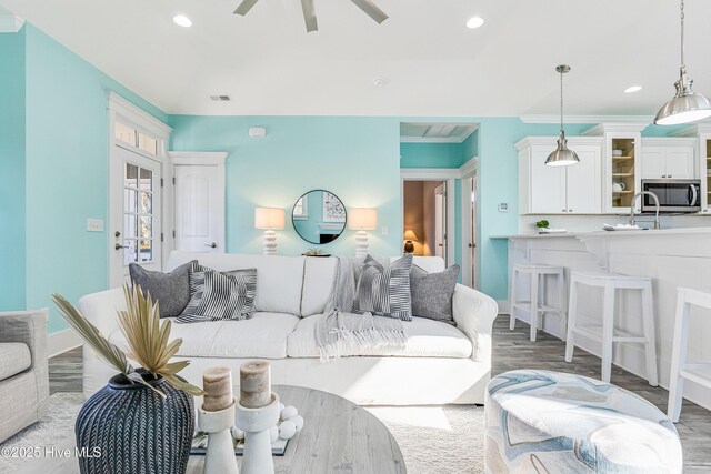 living room featuring visible vents, ornamental molding, recessed lighting, and a ceiling fan