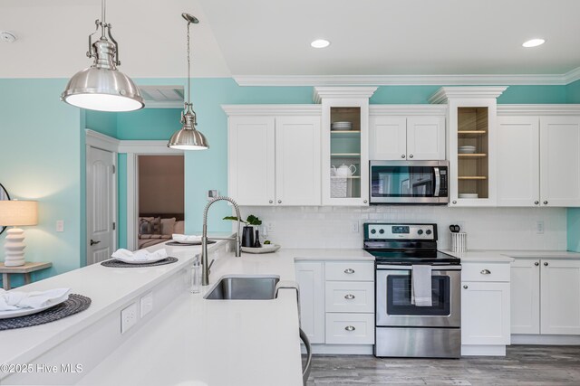 kitchen featuring white cabinets, a sink, light countertops, and appliances with stainless steel finishes