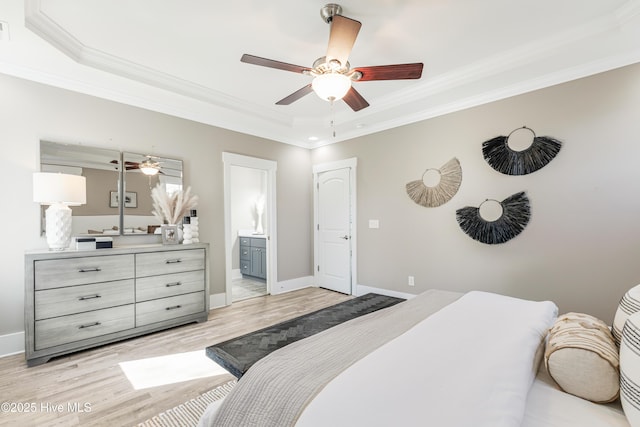 bedroom featuring baseboards, ornamental molding, light wood finished floors, and a raised ceiling