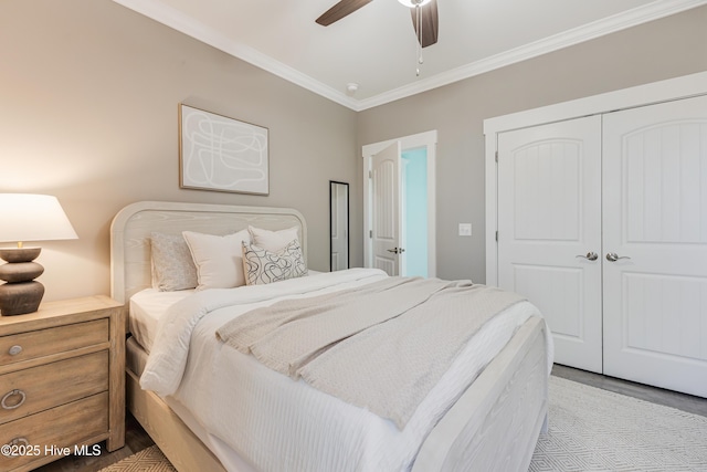 bedroom with crown molding, a closet, wood finished floors, and ceiling fan