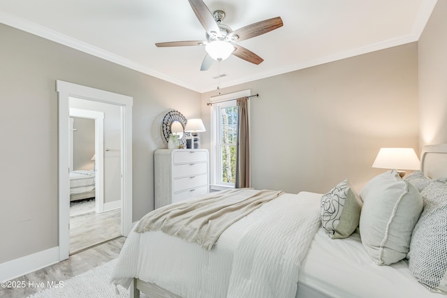 bedroom with visible vents, crown molding, baseboards, ceiling fan, and wood finished floors