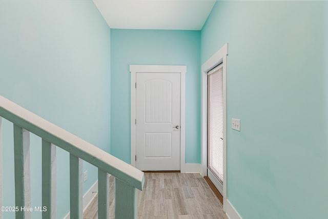 corridor featuring baseboards and light wood-style floors